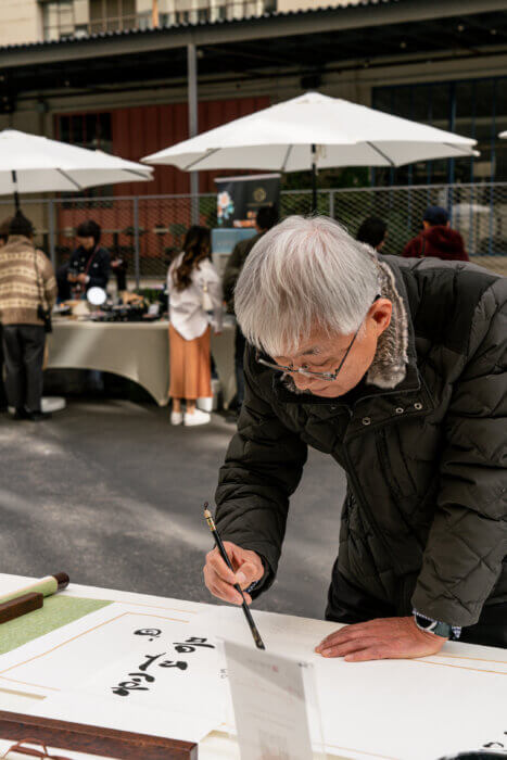 man doing calligraphy at hangawi korean festival