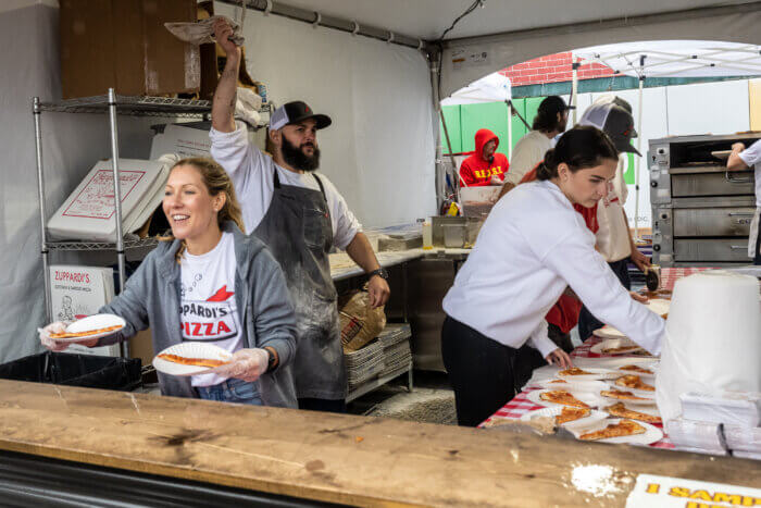 woman serving pizza at one bite pizza festival