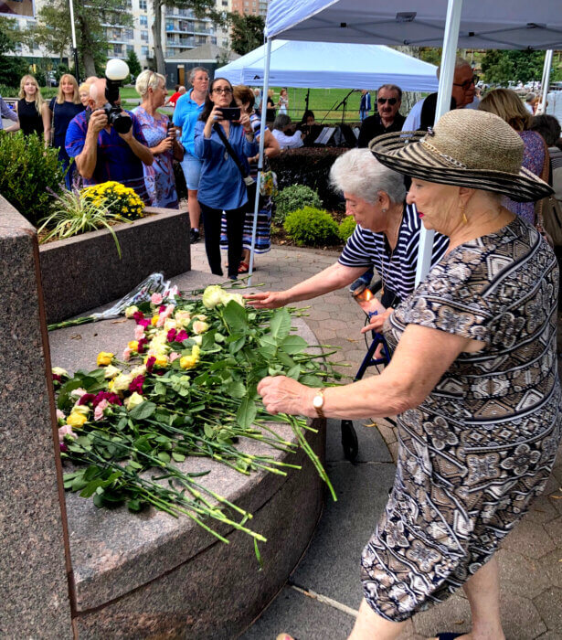 women lay down flowers at asser levy park