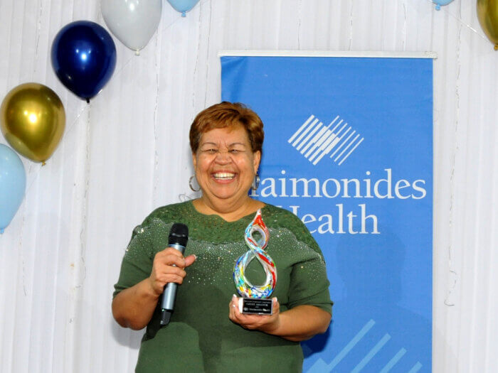 grisel amador holds award at maimonides