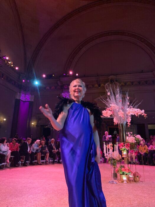 woman in blue dress at pink runway fundraiser