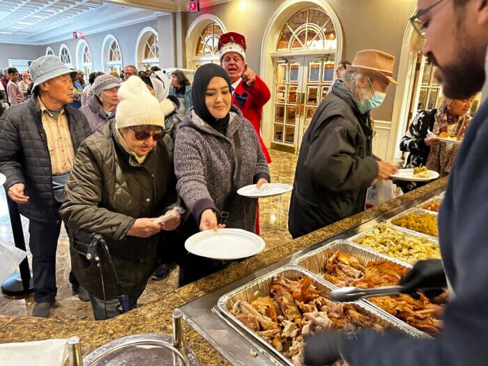 people serving food at coney island thanksgiving luncheon