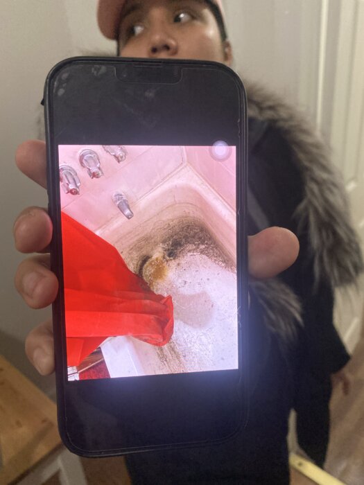 Evelyn De Leon shows pictures of how her bathtub was left without repairs when she first moved in. She also has a bed bug infestation, and a broken stove and refrigerator.