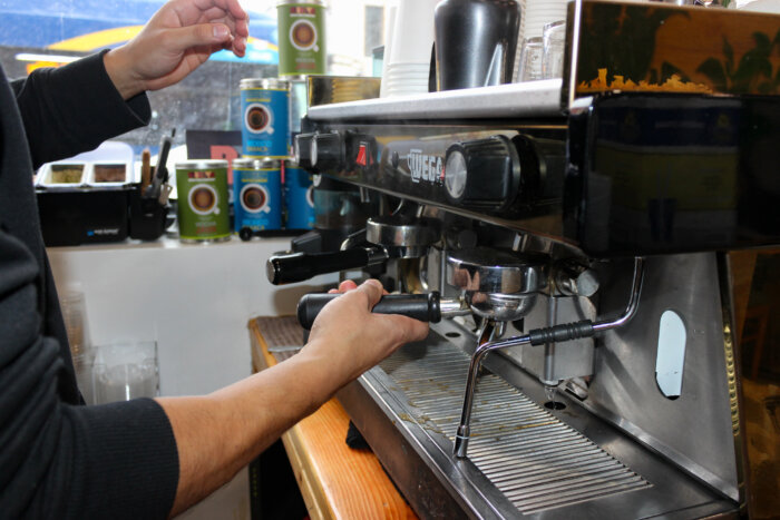 person making coffee at cafe xoco-latte