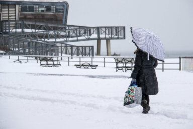 woman walking through snowstorm in coney island