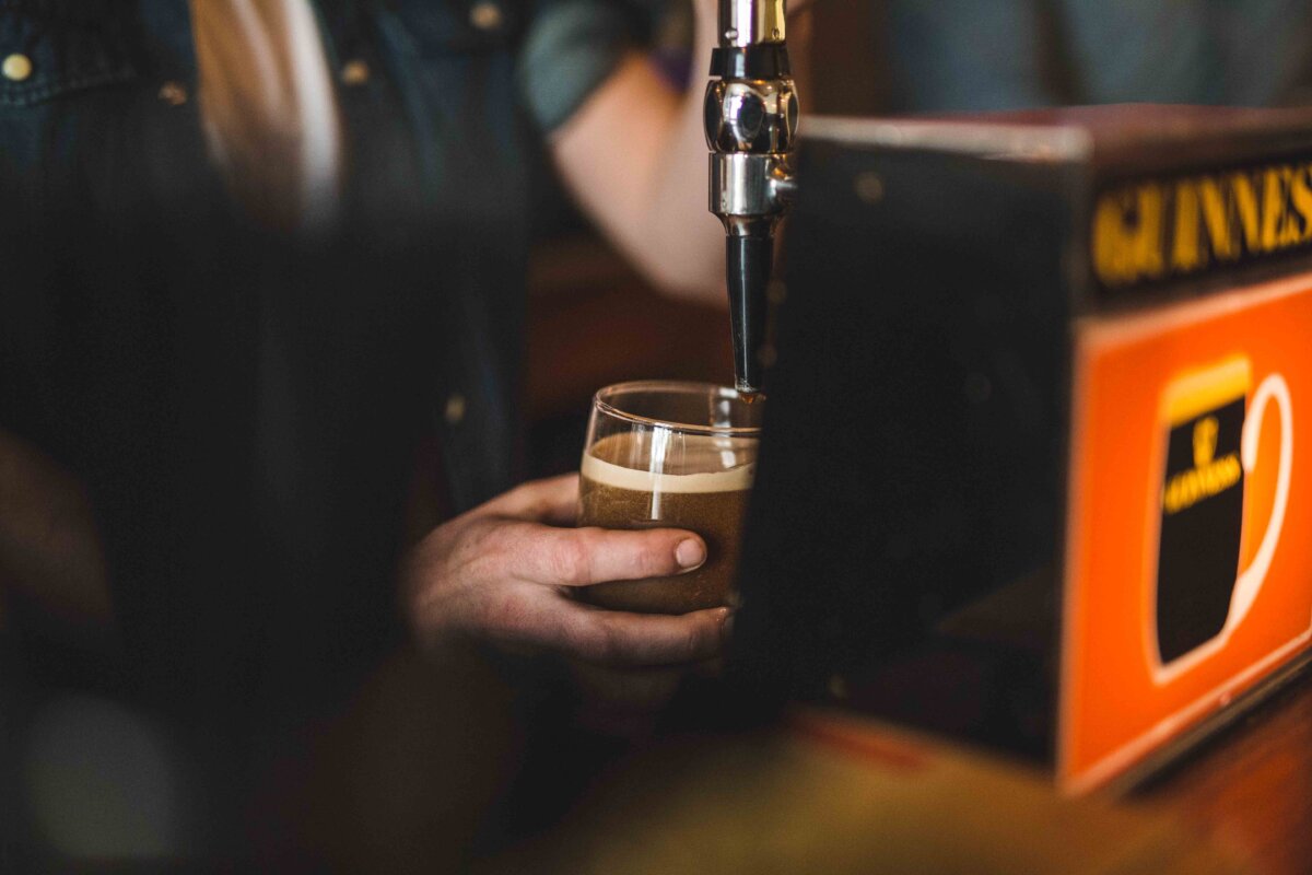 Person pulling pint of Guinness