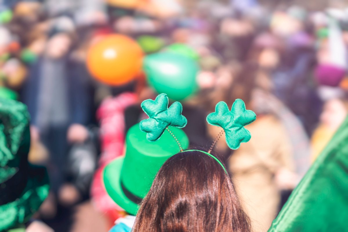 Clover head decoration on head of girl close-up. Saint Patrick day, parade in the city, selectriv focus