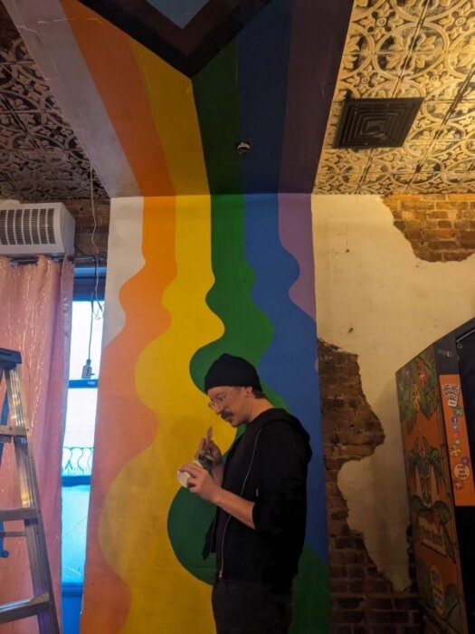 person painting rainbow on the wall