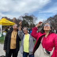 women in eclipse glasses at Green-Wood cemetery