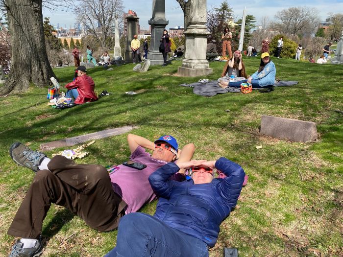 people watching the solar eclipse in green-wood cemetery