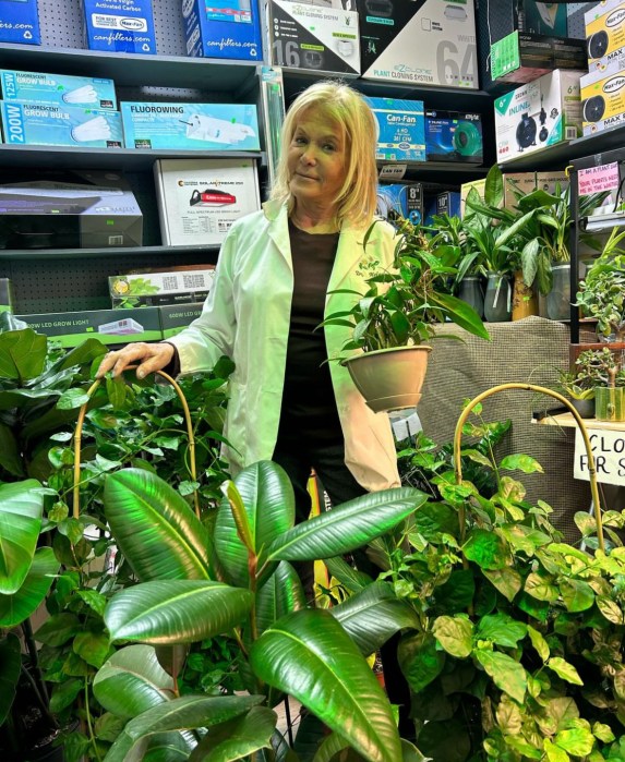 Helena De Paola poses next to her blooming shrubbery at her Bay Ridge storefront.