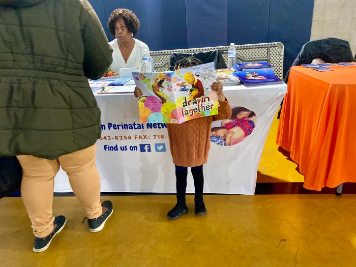 a child reads a book at a baby shower