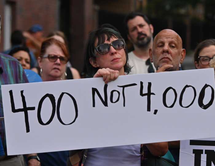 woman holding sign clinton hill shelter protest