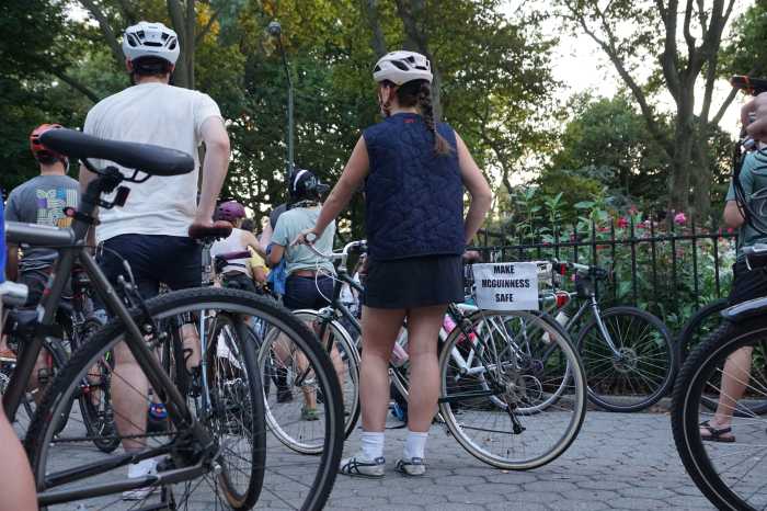 cyclist with make mcguinness safe sign at protest