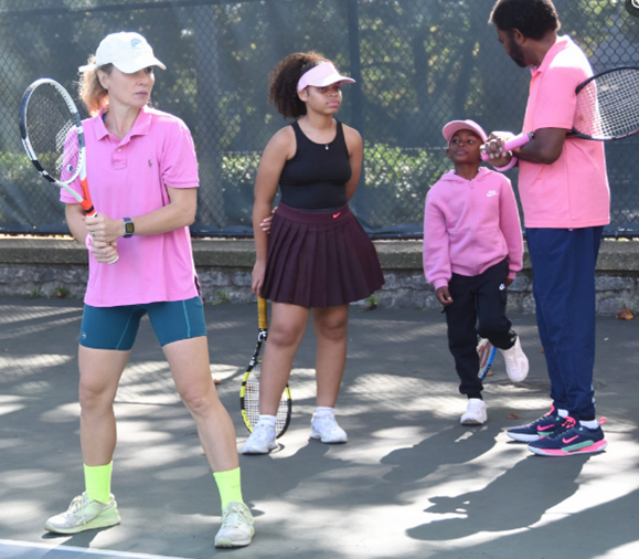 Pink love flowed through the courts as neighbors learned the fundamentals of tennis and tested their swing.