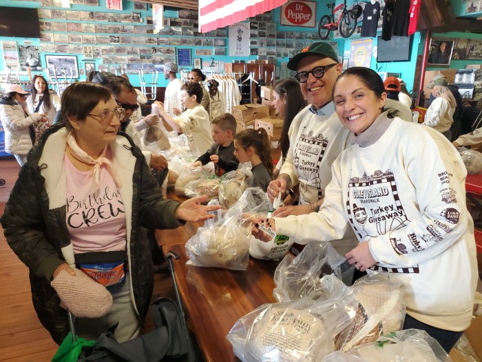 Politicians Brannan and Scarcella-Spanton give out turkeys to Coney Islanders.
