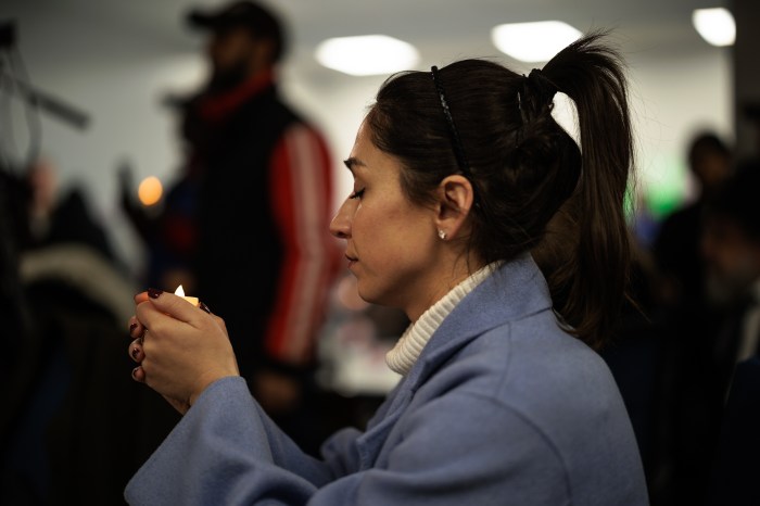woman praying at antisemitism event in brooklyn