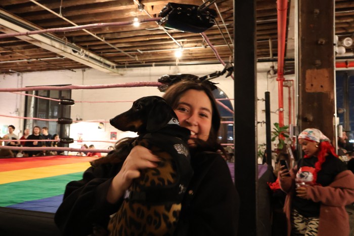 woman with dog in front of wrestling ring