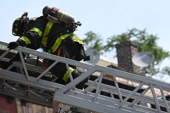 firefighter on ladder outside building