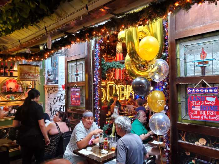 people eating at skinflints with decorations for restaurant's anniversary