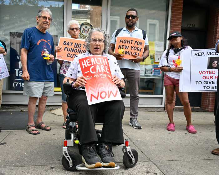 woman sitting in wheelchair holding protest sign