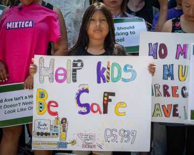child holding sign at street safety rally