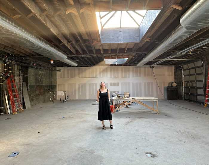 woman standing in empty teak new york building
