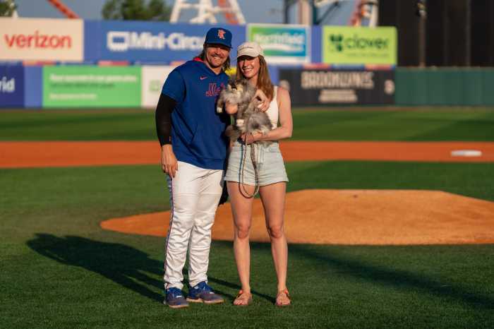couple with cat on field at cyclones game