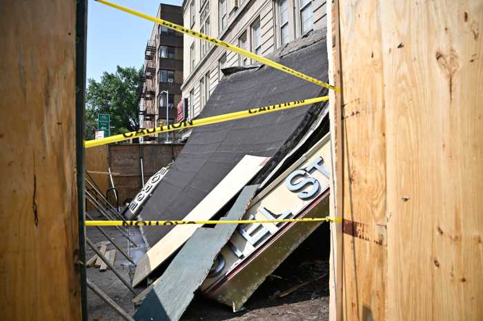 collapsed awning inside construction fence