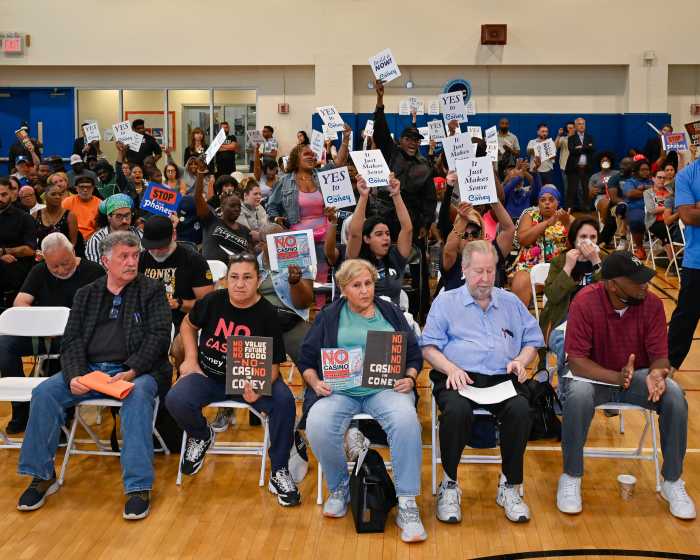 large group of people in meeting holding coney island signs