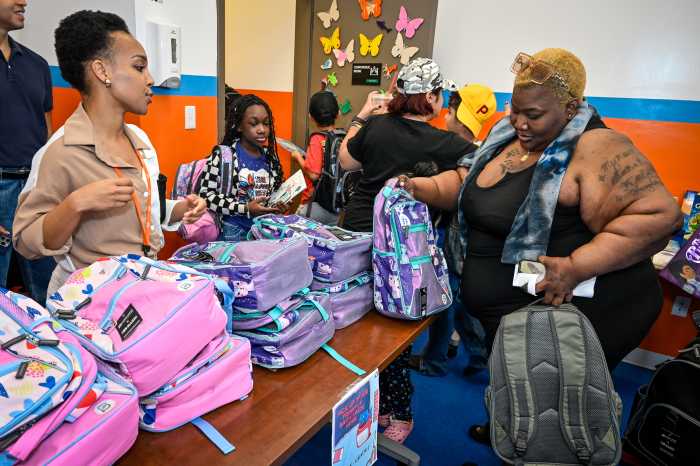 women looking at backpacks at back-to-school giveaway