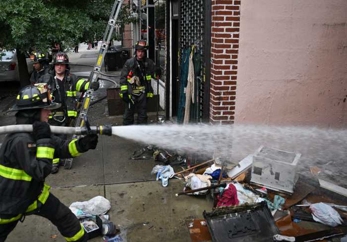 firefighter with items outside apartment building
