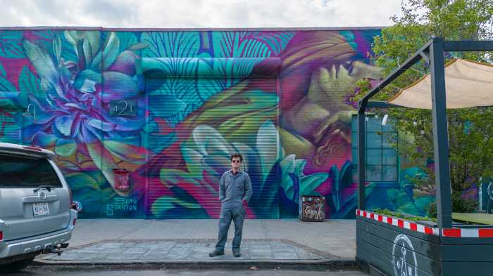 beau stanton in front of bushwick mural