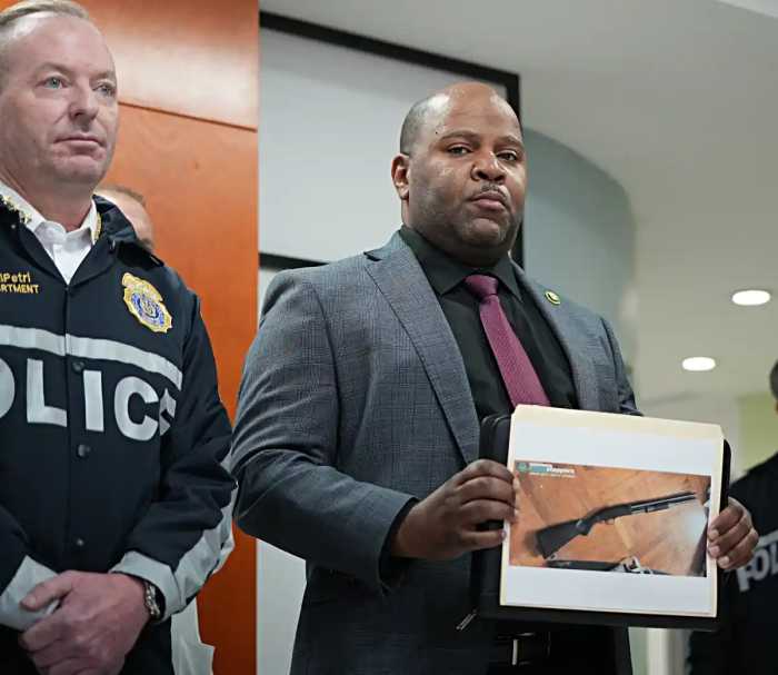 man holding photo of shotgun