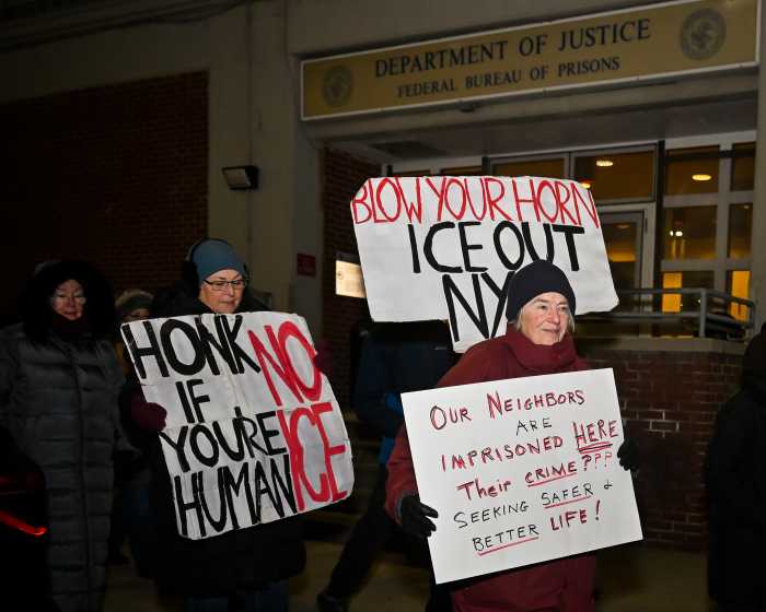 people with signs outside MDC vigil