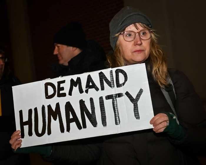 person holding sign at ice vigil